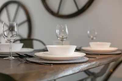 a table with plates and wine glasses on it at Granary Suite No22 - Donnini Apartments in Ayr