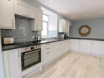 a kitchen with white cabinets and a counter top at Meadowbank in Girvan