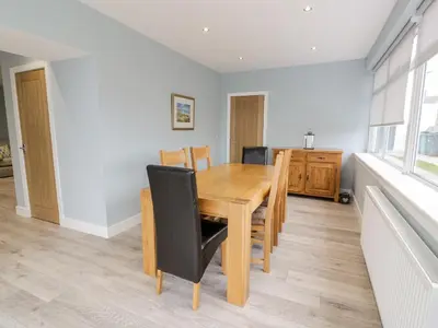 a dining room with a wooden table and chairs at Meadowbank in Girvan