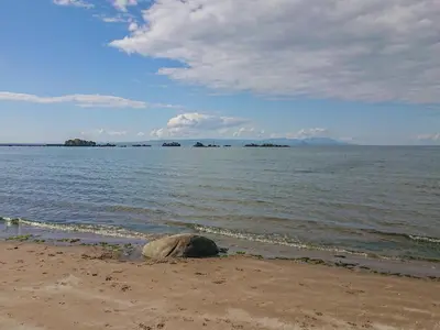 a rock sitting on the beach next to the water at Meadowbank in Girvan