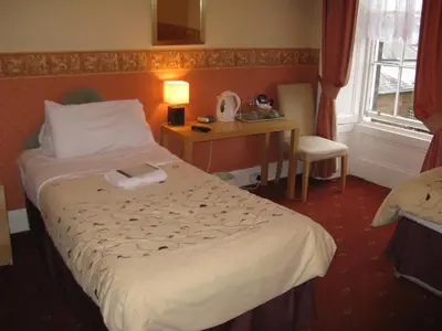 a hotel room with a bed and a desk and a window at Dumfries Villa in Dumfries