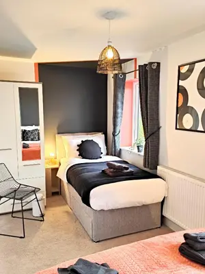 a bedroom with a bed with a black wall at Carvetii - Phoenix House - Near Hospital, max 8 ppl in Carlisle