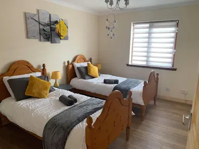 a bedroom with two beds and a window at Flat 18 in Dumfries