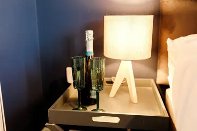 a nightstand with two glasses and a lamp on it at Annabelle's Den in Gatehouse of Fleet