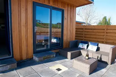 a patio with a couch and chairs on a building at Annabelle's Den in Gatehouse of Fleet