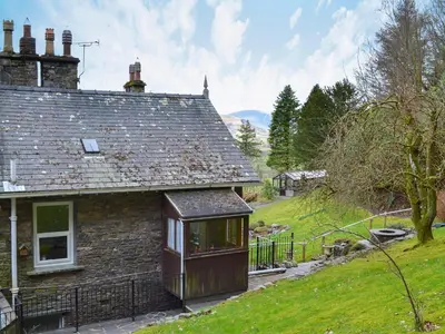 an old stone house with a large window at Squirrels Retreat - Uk30821 in Braithwaite