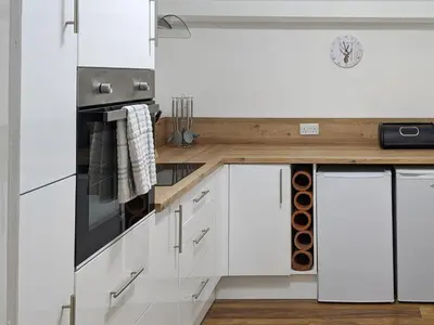 a kitchen with white cabinets and a stove top oven at Squirrels Retreat - Uk30821 in Braithwaite