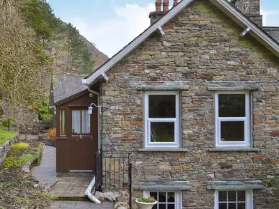 a stone house with a door and two windows at Squirrels Retreat - Uk30821 in Braithwaite