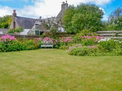 a garden with a bench in the yard at Culpee House in Newton Stewart