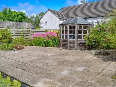 a garden with a greenhouse in front of a house at Culpee House in Newton Stewart