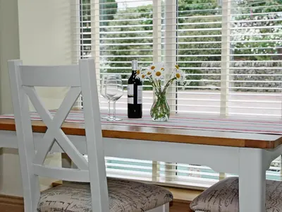 a table with a bottle of wine and a glass at Swallows in Girthon