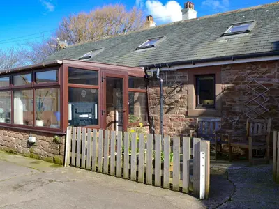 a house with a wooden fence in front of it at The Milking Parlour - Uk30866 in St Bees