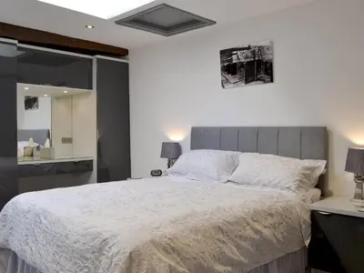 a bedroom with a large bed with a gray headboard at The Milking Parlour - Uk30866 in St Bees