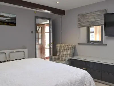 a bedroom with a white bed and a chair at The Milking Parlour - Uk30866 in St Bees