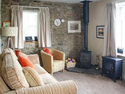 a living room with a couch and a wood stove at The Coach House - Uk30813 in Braithwaite