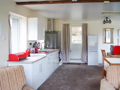 a kitchen with white cabinets and a red appliance at The Coach House - Uk30813 in Braithwaite