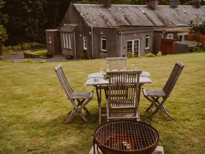 a table with chairs and a grill in a yard at Wild Geese Lodge - Uk31046 in Portpatrick