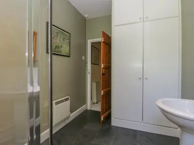 a bathroom with a sink and a shower and a toilet at Acorn Cottage in Coniston