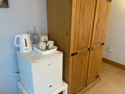 a small refrigerator with a coffee maker on top of it at Lakeland Snug in Keswick