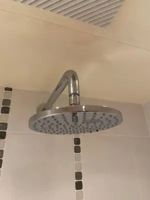 a metal ceiling fan hanging from a ceiling at Lakeland Snug in Keswick