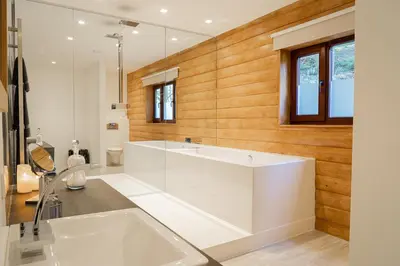 a white bathroom with a tub and a sink at Tholt-y-Will B&B in Sulby