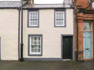 a white house with blue windows and a door at The Precinct House in Newton Stewart