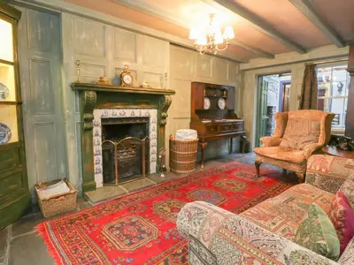 a living room with a fireplace and a couch and a chair at The Precinct House in Newton Stewart
