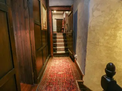 a hallway with stairs and a red rug at The Pend in Newton Stewart