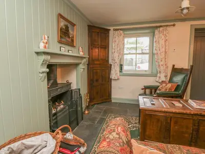 a living room with a fireplace and a chair at Faldarroch Farm in Newton Stewart