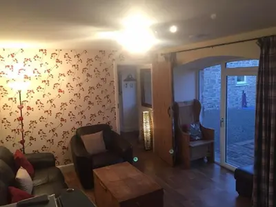 a living room with a couch and a chair at The Stables in Castle Douglas