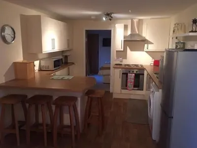 a kitchen with a table and chairs and a refrigerator at The Stables in Castle Douglas