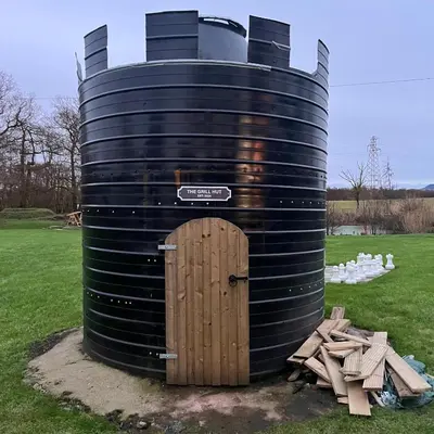 a black barrel with a door in a field at The Stables in Castle Douglas