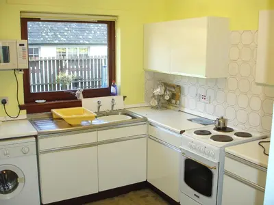 a kitchen with white cabinets and a sink and a window at Lavender Cottage with Parking and Beautiful Views Christmas Special in Carsphairn