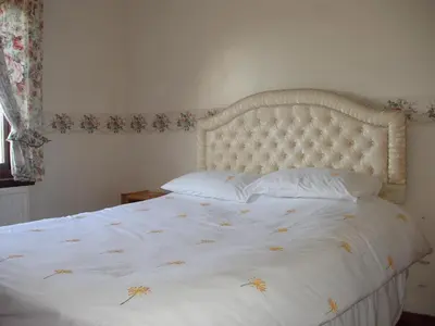 a bed with a white bedspread and pillows on it at Lavender Cottage with Parking and Beautiful Views Christmas Special in Carsphairn
