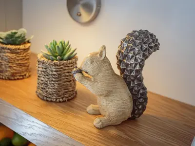 a cat figurine sitting on a table looking at a pineapple at Squirrel Cottage in Stranraer