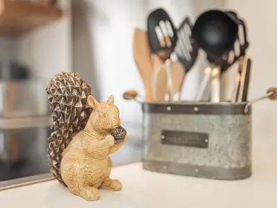 a figurine of a cat standing on a counter next to a container at Squirrel Cottage in Stranraer