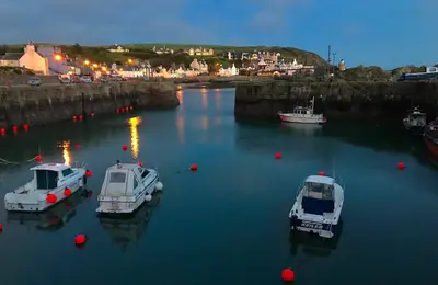 three boats are docked in a harbor at night at Ardbeg 4 - Farm Stay with Sea Views across to Northern Ireland in Stranraer
