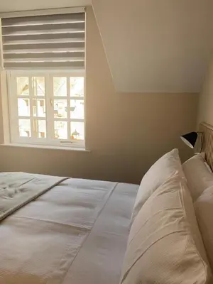 a white bed in a room with a window at 5a Bank Street in Keswick