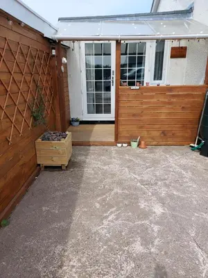 a patio with a wooden fence and a house at Hadrians wall studio in Carlisle