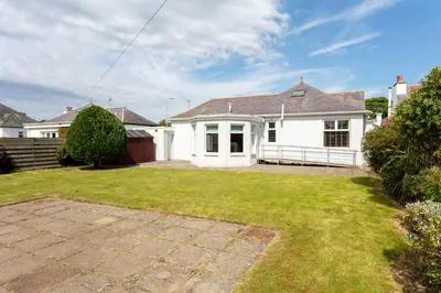 a white house with a lawn in front of it at Seafield House - Donnini Apartments in Ayr