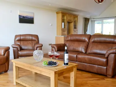 a living room with a couch and a table with wine glasses at Auchen Ladder in Amisfield Town
