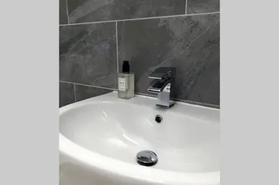 a bathroom sink with a bottle of soap on it at Albion Cottage in Cockermouth