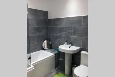 a bathroom with a sink and a tub and a toilet at Albion Cottage in Cockermouth
