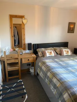 a bedroom with a bed and a desk and a mirror at Jacquie's B&B -Dumfries-Room with a view in Dumfries