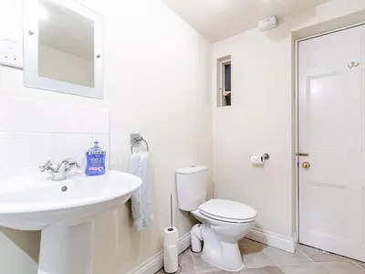 a white bathroom with a toilet and a sink at Sharrow View in Watermillock