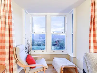 a living room with a chair and a window at Sharrow View in Watermillock