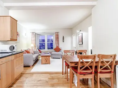a kitchen and living room with a table and chairs at Sharrow View in Watermillock