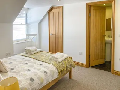 a bedroom with a bed with two towels on it at Ardstinchar Mews in Ballantrae