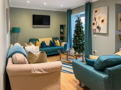 a living room with two couches and a christmas tree at Ardstinchar Mews in Ballantrae