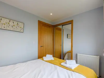 a bedroom with a bed with two towels on it at Sand View in Mainsriddle